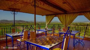 a room with two tables and a chess board on a balcony at Dar Amoudou in Ouarzazate