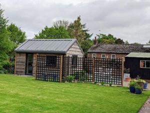 a fence in a yard next to a house at La'al Cabin, tiny home, unique space Eden Valley Cumbria in Brampton