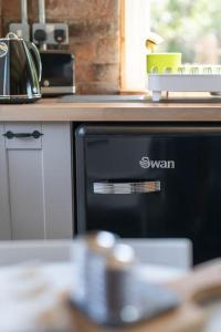 a dishwasher in a kitchen next to a counter at La'al Cabin, tiny home, unique space Eden Valley Cumbria in Brampton