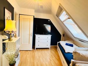 Dormitorio pequeño en el ático con cama y TV en Ferienwohnung Luna -3 Schlafzimmer, Waschmaschine, Küche, WLAN, ca 15 Min bis zum Europa Park,, en Malterdingen