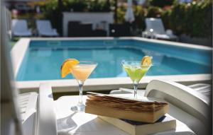 Dois cocktails numa mesa ao lado de uma piscina em Pet Friendly Apartment In Split With Kitchen em Split