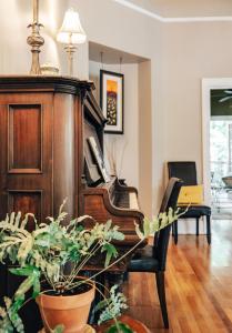 um piano numa sala de estar com um vaso de plantas em Princess Anne Boutique Hotel & Breakfast em Asheville