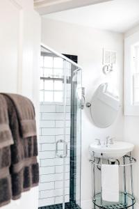 ein weißes Badezimmer mit einem Waschbecken und einem Spiegel in der Unterkunft Princess Anne Boutique Hotel & Breakfast in Asheville
