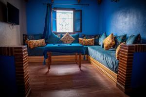 a blue living room with a couch and a window at Blue House Town in Chefchaouen