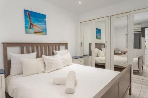 1 dormitorio con 1 cama blanca grande con almohadas blancas en Casa Julia en Playa de las Americas