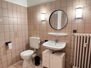 a bathroom with a toilet and a sink and a mirror at Apartment an der Altstadt in Hameln +10 photos