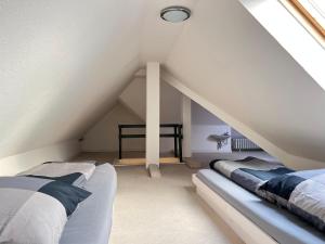 a attic bedroom with two beds and a window at Apartment an der Altstadt in Hameln