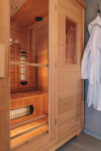 a walk in closet with wooden walls and a door at Wellness Bed & Breakfast by Leef in Maasland