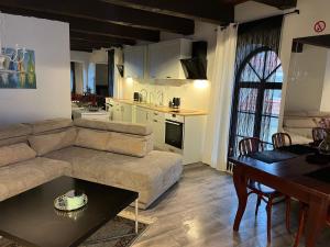 a living room with a couch and a table and a kitchen at Tiltų 5 Apartment in Klaipėda