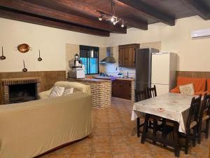 eine Küche mit einem Sofa, einem Tisch und einem Kühlschrank in der Unterkunft El Romeral in Algodonales