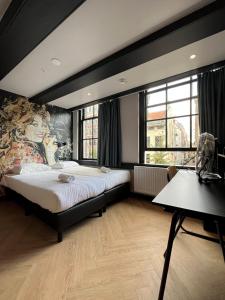 Heart of Amsterdam Hotel في أمستردام: غرفة نوم بسرير كبير ولوحة كبيرة على الحائط
