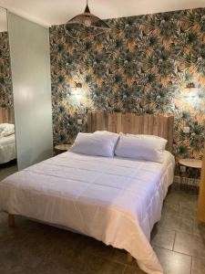 a bedroom with a large bed with a floral wallpaper at Gîte "le haut des Poujades" in Reilhaguet