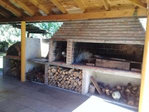 an outdoor brick oven with a pile of logs at La Villarense in Buenos Aires