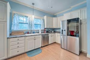 een keuken met witte kasten en een roestvrijstalen koelkast bij Burgaw House with Large Covered Porch and Swing! 