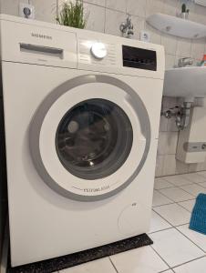 a white washing machine in a bathroom next to a sink at Flensburg Zentrum 69 05 in Flensburg +17 photos