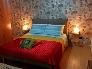 - une chambre avec un lit avec une couverture rouge et 2 lampes dans l'établissement Casa-B&B Bouganville Attico 85 mq, à Barletta