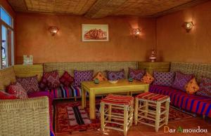 a room with a couch and a table and chairs at Dar Amoudou in Ouarzazate