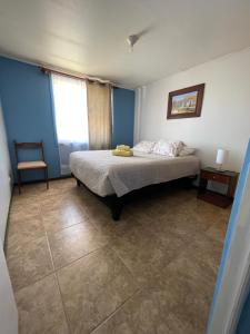 a bedroom with a bed in a room with blue walls at Cabañas Pankara in San Pedro de Atacama