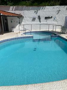 a large swimming pool with blue water at Pousada Farol do Morro in Morro de São Paulo