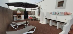 un patio con sombrilla, mesa y sillas en Villa Elisa en Villaverde