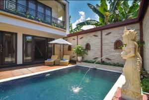 una piscina con statua di fronte a una casa di Villa Mozart 1 a Lovina