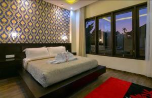 una camera da letto con un letto e un asciugamano sopra di Villa Mozart 1 a Lovina Altre 35 foto