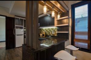 una cucina con bar con due sgabelli bianchi di Villa Mozart 1 a Lovina
