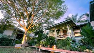 a house with a tree in front of it at Rimsira in Chumphon