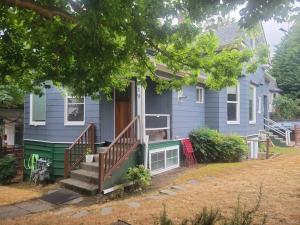 een blauw huis met een veranda met een houten deur bij Large funky 2 or 3 bedroom unit in prime location in Seattle