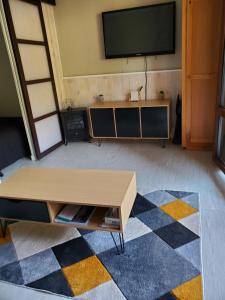 sala de estar con TV y mesa de centro en Agréable appartement-Résidence Le Panoramic, en Les Angles