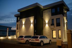 萨图马雷Hotel Vila Discret的两辆汽车停在一栋建筑前的停车场