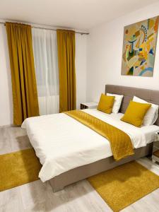 a bedroom with two beds with yellow pillows at Hils Pallady Apartment Lyly in Bucharest