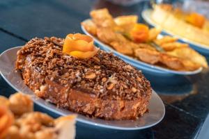 um bolo de chocolate num prato com outros pratos de comida em Amendoeira Praia Hotel em Morro de São Paulo