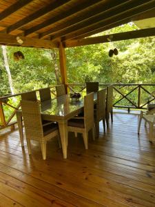una mesa y sillas en un porche con vistas al bosque en Hacienda Claro de Luna 3 Bedrooms, en Jarabacoa