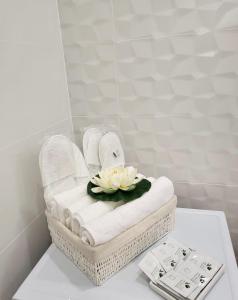 a bathroom with a towel basket with a flower on it at Hils Pallady Apartment Lyly in Bucharest