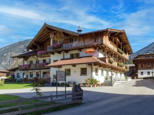 a large building with a wooden roof at Apart Landhaus Heim in Mayrhofen