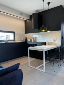 a kitchen with a white table and black cabinets at La Torre del Porto in Riccione