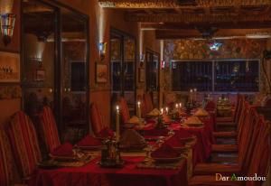 a long dining room with red tables and chairs at Dar Amoudou in Ouarzazate