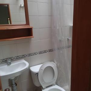 y baño con aseo blanco y lavamanos. en El Prado EcoHotel, en Montenegro