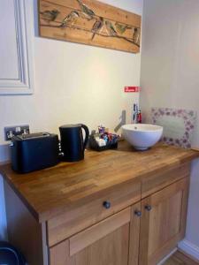 a wooden counter with a sink and a bowl on it at The Snug with Jacuzzi -cosy hideout in Coventry