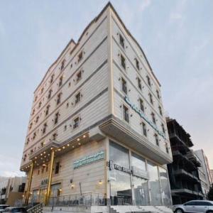 a large white building on a city street at زهرة الربيع للشقق المخدومة zahrat alrabie Hotel in Jeddah
