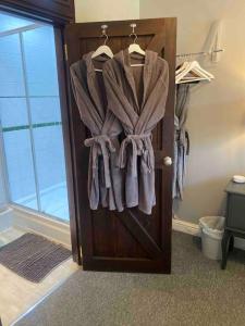 a wooden door with towels hanging on it at The Snug with Jacuzzi -cosy hideout in Coventry