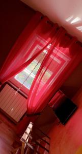 a red bed canopy with a window in a room at Domaine de la Borde in Damparis