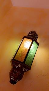 une lampe suspendue à un mur avec une lumière verte dans l'établissement Domaine de la Borde, à Damparis