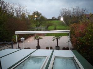 a view of a patio with two windows and trees at Domaine de la Borde in Damparis
