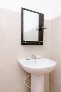 uma casa de banho com um lavatório e um espelho em Savenndra Hotel em Ranala