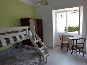1 dormitorio con litera, mesa y sillas en Logement calme et authentique à Espelette, en Espelette