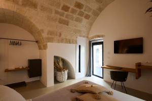 a bedroom with a bed and a tv on a wall at Musae Relais & SPA in Polignano a Mare