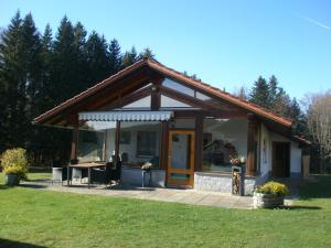 a small house with a table in the grass at Ferienhaus Hütter in Neuschönau