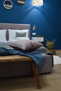 1 dormitorio con 1 cama con pared azul en Althof Apartments en Sibiu